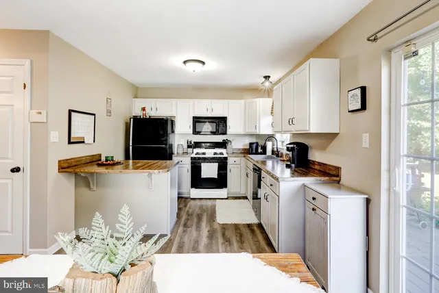 a kitchen with stainless steel appliances kitchen island granite countertop a refrigerator oven a sink a stove with dining table and chairs