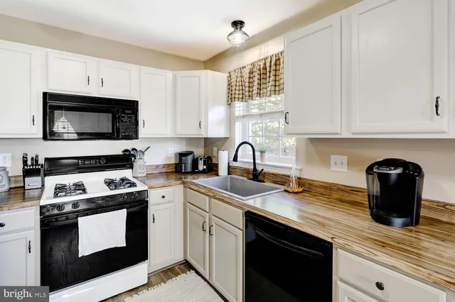 a kitchen with stainless steel appliances granite countertop a stove a sink dishwasher and a microwave oven with cabinets