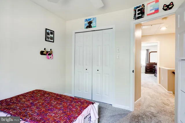 a bedroom with a bed and a refrigerator