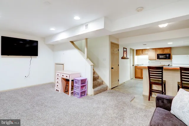 a view of kitchen with stainless steel appliances cabinets and chair