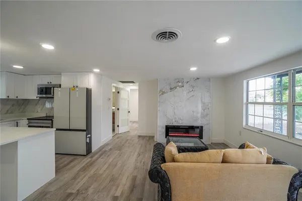 a living room with furniture and a refrigerator