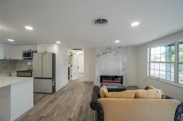 a living room with furniture and a refrigerator