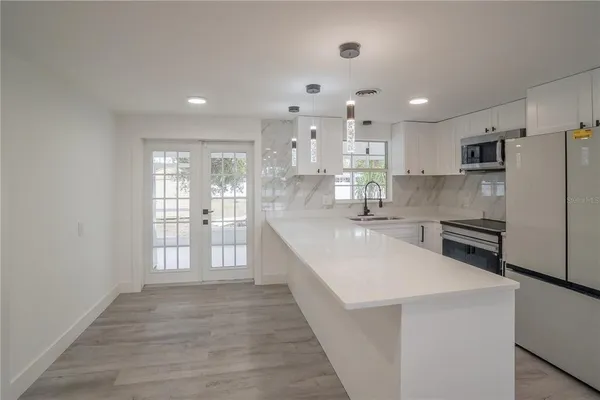 a large kitchen with kitchen island a sink stainless steel appliances and cabinets