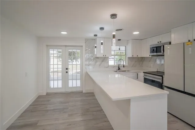 a large kitchen with kitchen island a sink stainless steel appliances and cabinets