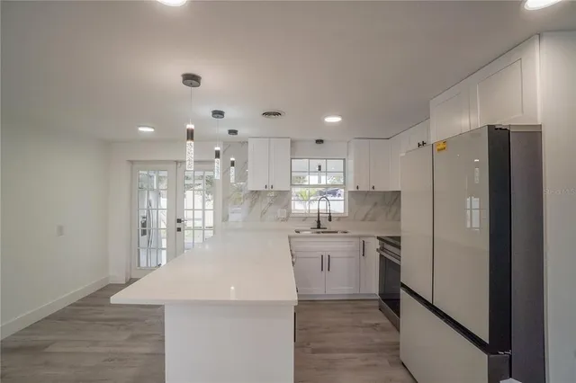 a large kitchen with kitchen island a sink stainless steel appliances and cabinets