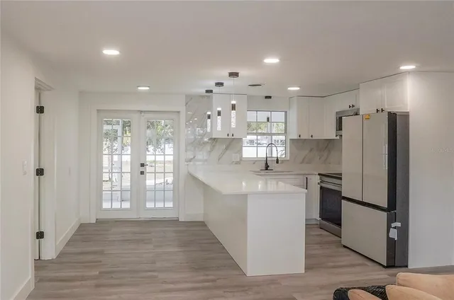 a kitchen with stainless steel appliances a refrigerator sink and microwave