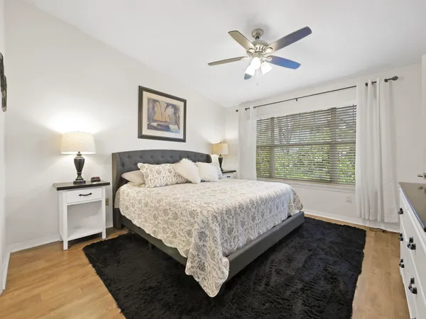 a bedroom with a bed a dresser and a flat screen tv