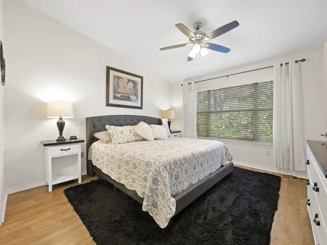 a bedroom with a bed a dresser and a flat screen tv