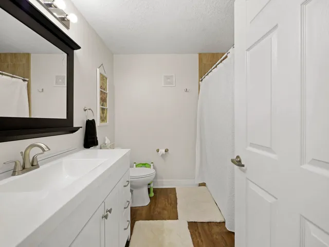a en suite bathroom with a granite countertop sink and a mirror