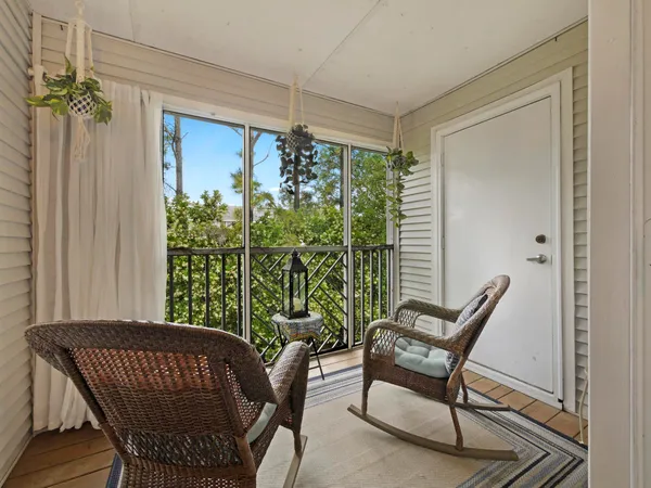 a living room with large windows and a potted plant