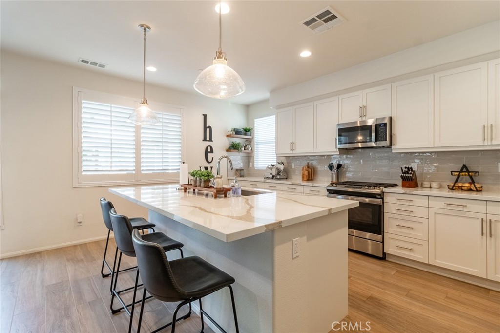 1827 Montecito Lane Redlands, CA 92374 - Photo 14 of 60 a kitchen with a stove a sink a kitchen island with a dining table and chairs