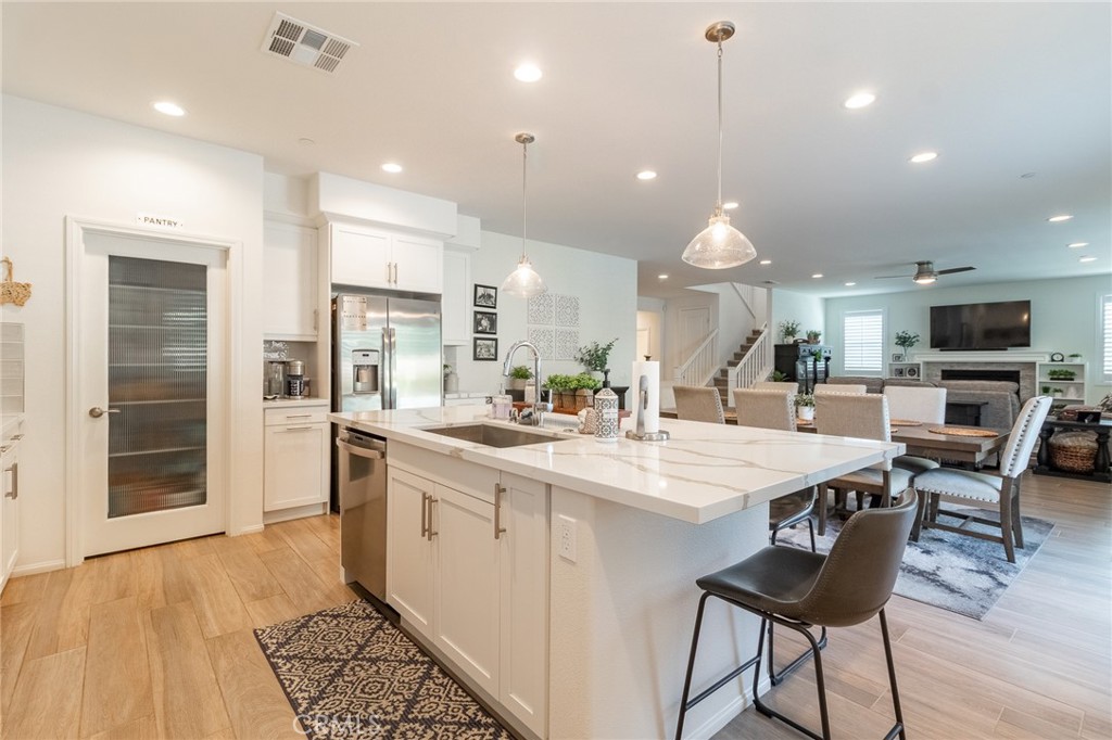 1827 Montecito Lane Redlands, CA 92374 - Photo 17 of 60 a large kitchen with granite countertop a stove a sink a refrigerator and a dining table with wooden floor