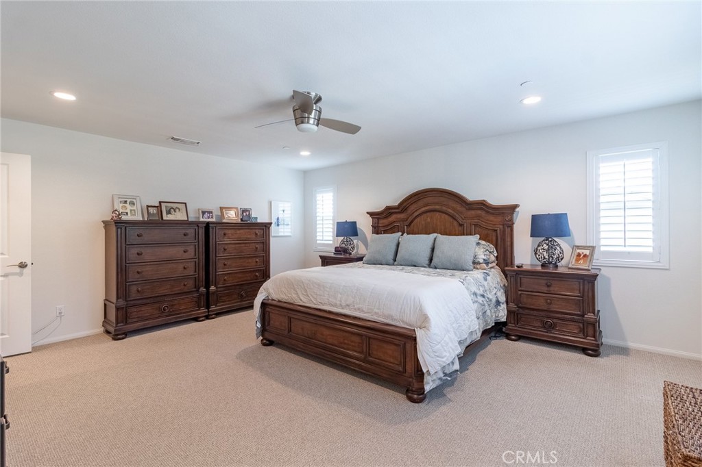 1827 Montecito Lane Redlands, CA 92374 - Photo 40 of 60 a spacious bedroom with a bed a dresser and a chandelier