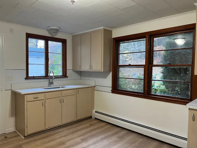 a view of a kitchen with a sink dishwasher and wooden cabinets