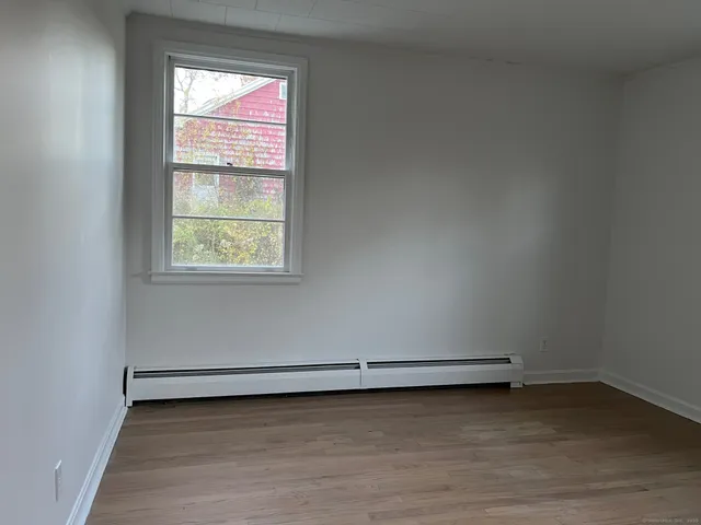a view of a room with wooden floor and window