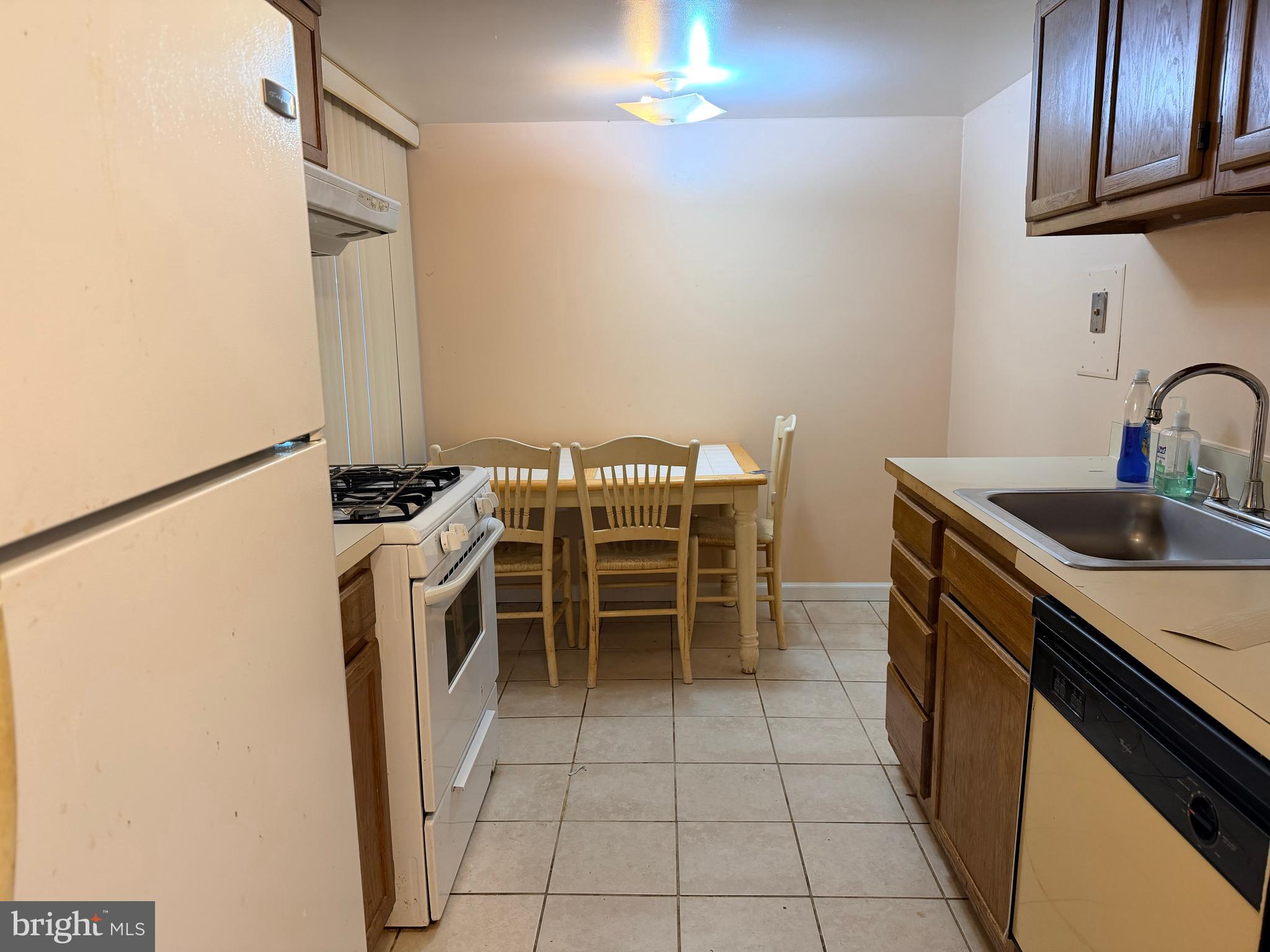 5247 West Running Brook Road, Unit 102 Columbia, MD 21044 - Photo 9 of 28 a kitchen with a sink a stove and a refrigerator