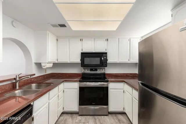 a en suite bathroom with a granite countertop sink a mirror and a shower