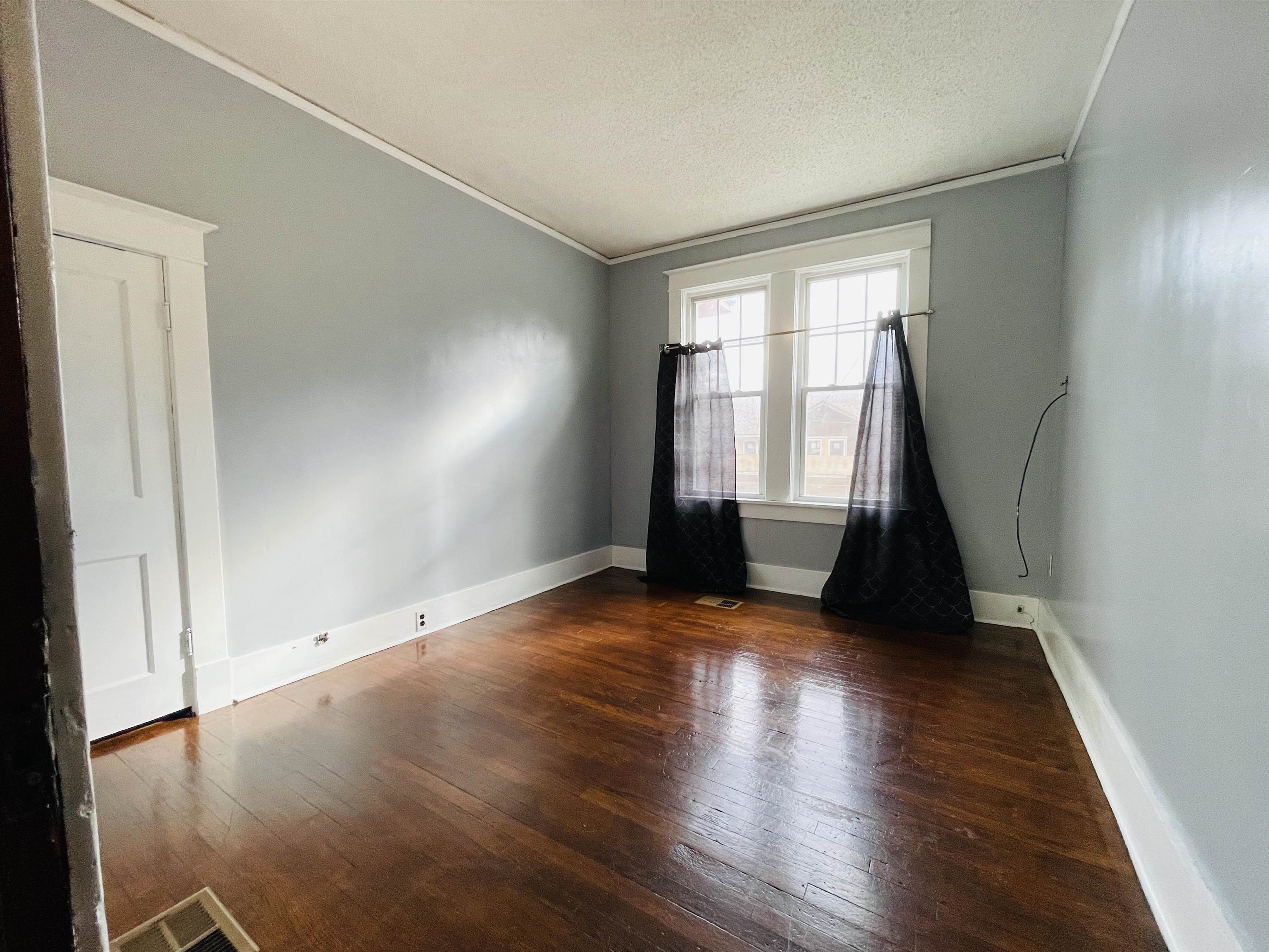 1009 Rozelle Street Memphis, TN 38114 - Photo 22 of 40 Unfurnished room featuring dark hardwood / wood-style floors, crown molding, and a textured ceiling