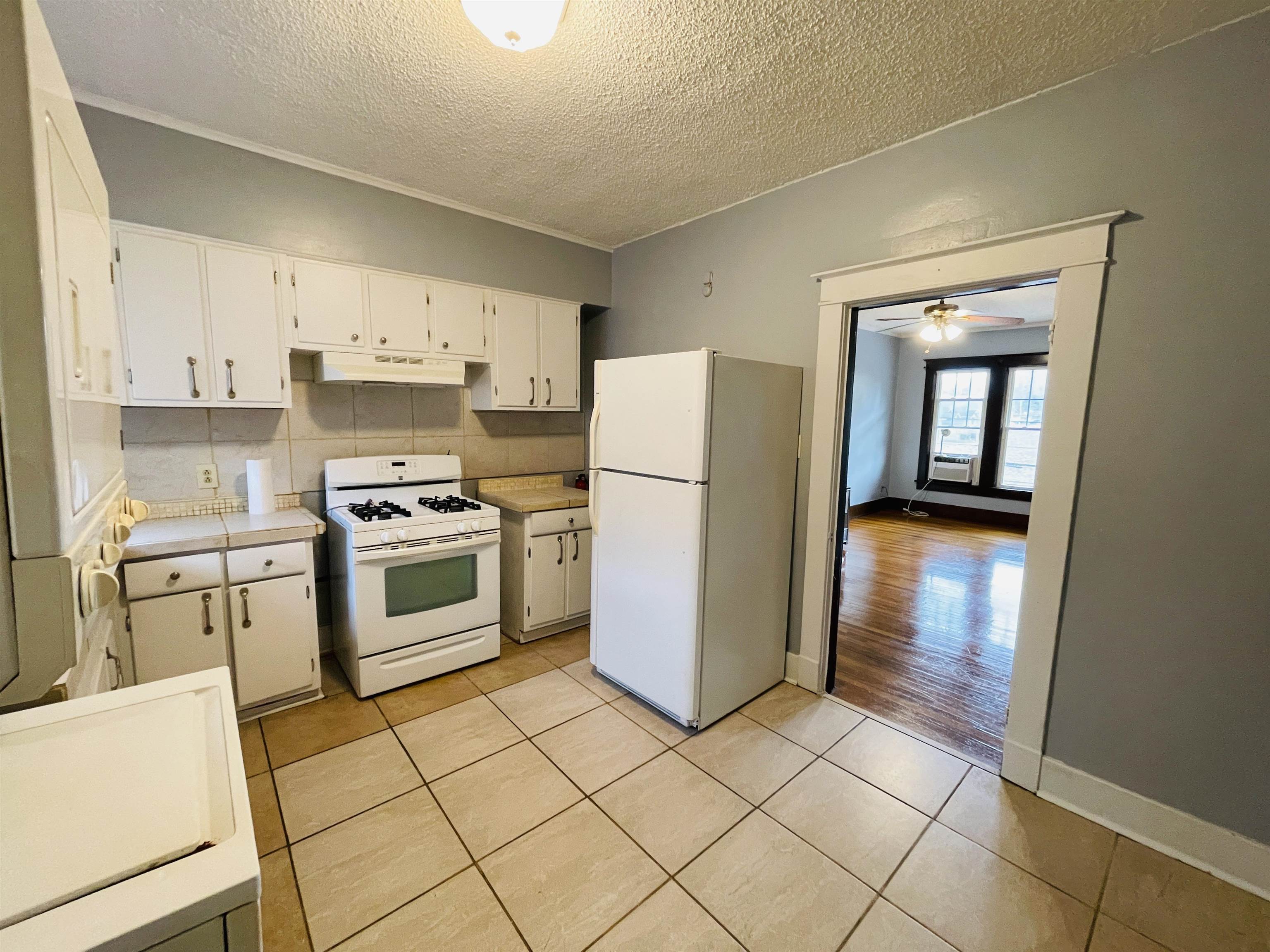 1009 Rozelle Street Memphis, TN 38114 - Photo 32 of 40 Kitchen with tasteful backsplash, white appliances, ceiling fan, light tile patterned floors, and white cabinets