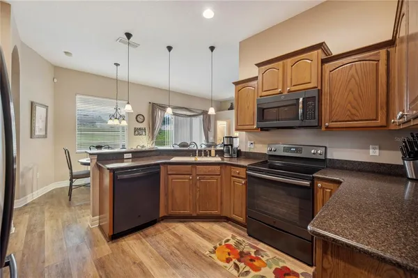a kitchen with stainless steel appliances granite countertop a stove a sink and a microwave