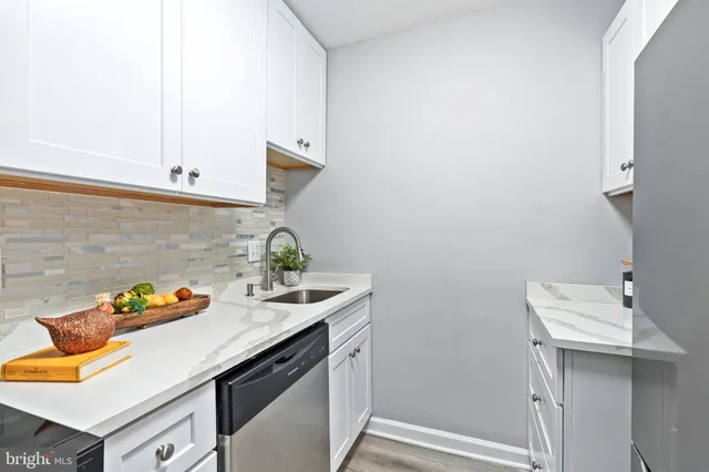 a kitchen with stainless steel appliances granite countertop a sink a stove and cabinets