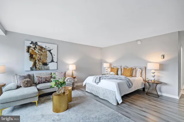 a bedroom with a bed table chair and couch