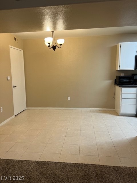 7885 West Flamingo Road, Unit 1064 Las Vegas, NV 89147 - Photo 8 of 19 Unfurnished dining area featuring light tile patterned floors, baseboards, and visible vents