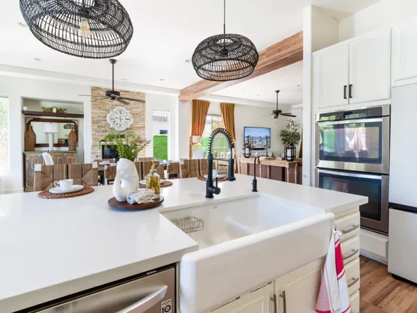 a kitchen with a sink a chandelier and living area view