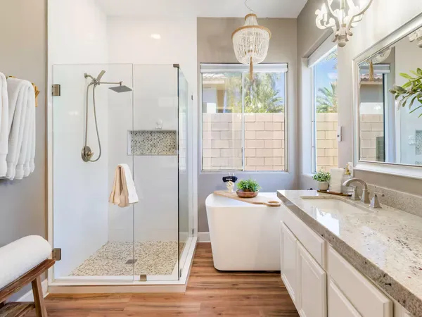 a bathroom with a granite countertop sink a large mirror and a bathtub
