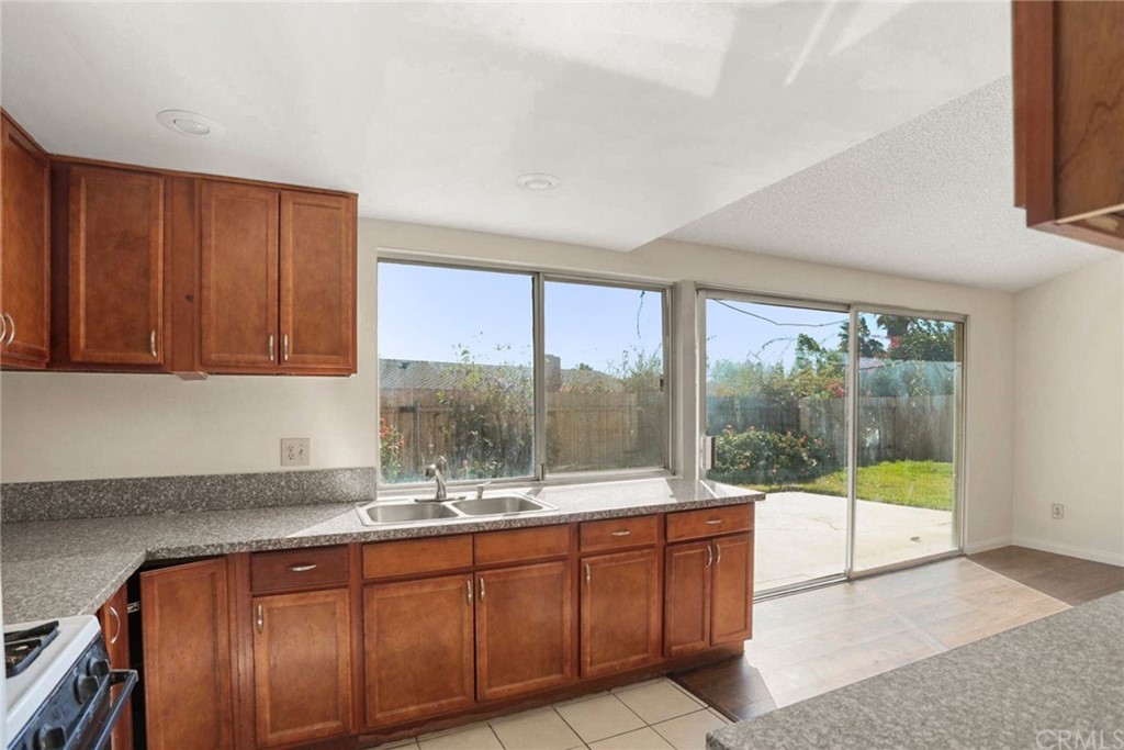 340 Maravilla Drive Riverside, CA 92507 - Photo 11 of 35 a kitchen with granite countertop a stove a sink and a wooden cabinets