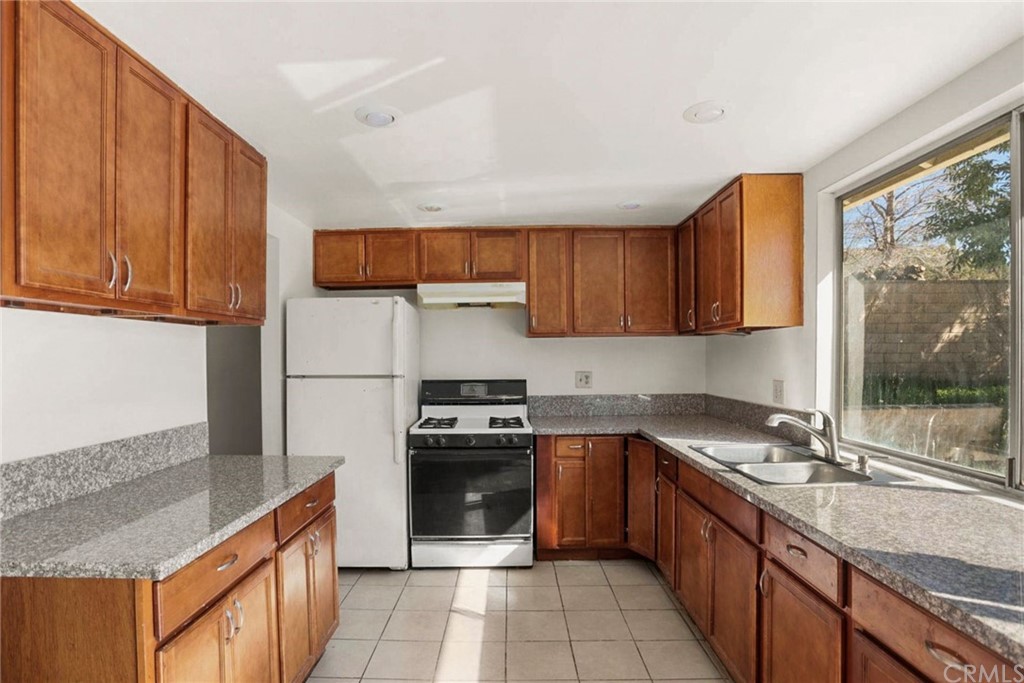 340 Maravilla Drive Riverside, CA 92507 - Photo 14 of 35 a kitchen with stainless steel appliances granite countertop a sink stove and refrigerator