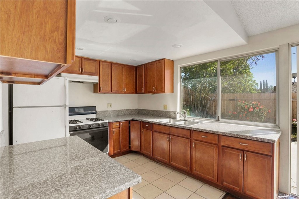 340 Maravilla Drive Riverside, CA 92507 - Photo 16 of 35 a kitchen with stainless steel appliances granite countertop a stove a sink and a refrigerator