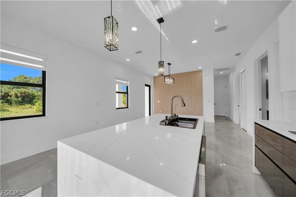 711 Roma Avenue South Lehigh Acres, FL 33974 - Photo 12 of 38 a view of a kitchen with a sink and chandelier