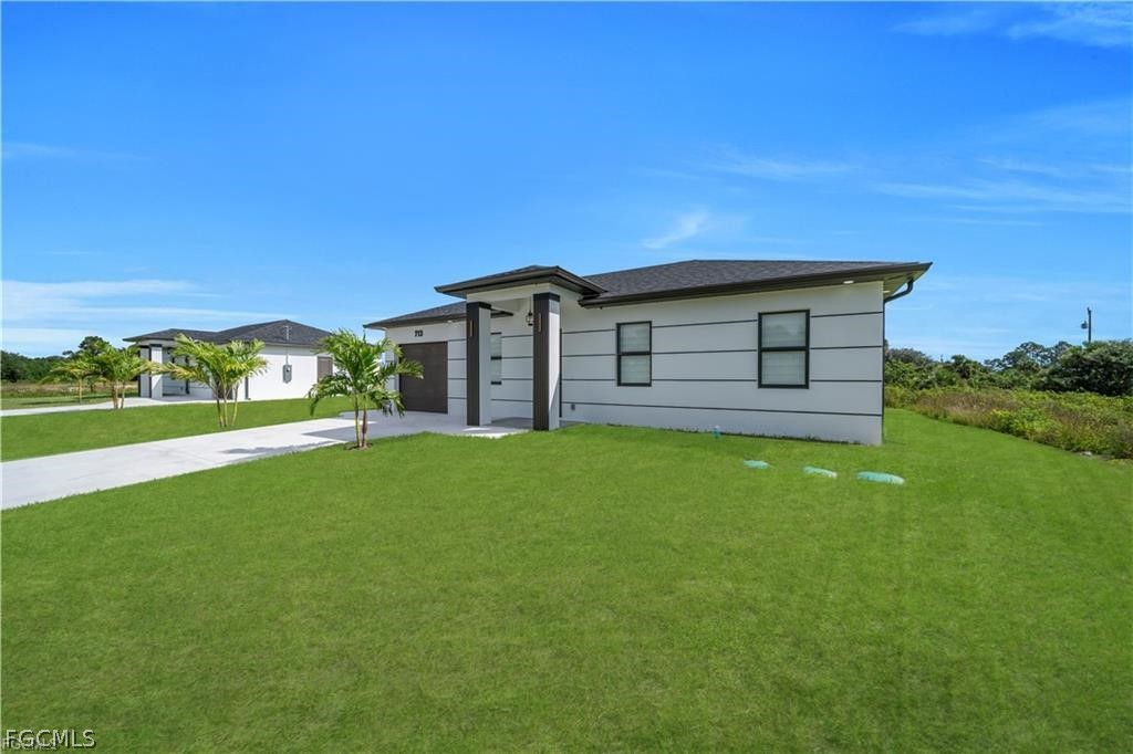 711 Roma Avenue South Lehigh Acres, FL 33974 - Photo 2 of 38 a view of a house with a backyard