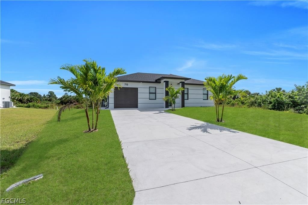 711 Roma Avenue South Lehigh Acres, FL 33974 - Photo 3 of 38 a view of a house with a yard and potted plants