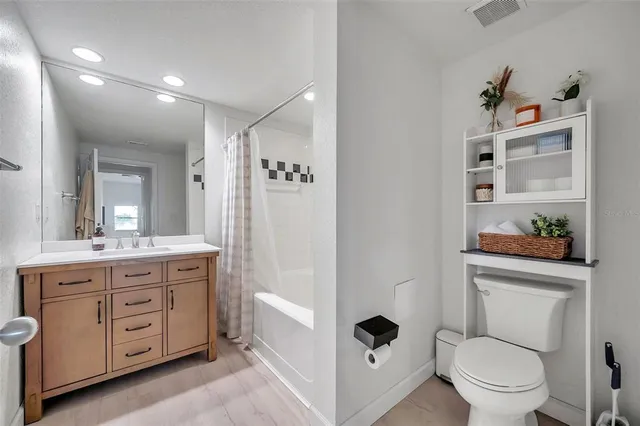 a spacious bathroom with a toilet sink double vanity and mirror