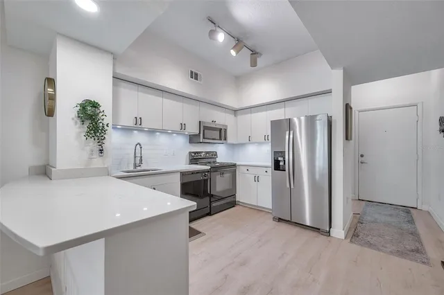 a kitchen with white cabinets and stainless steel appliances