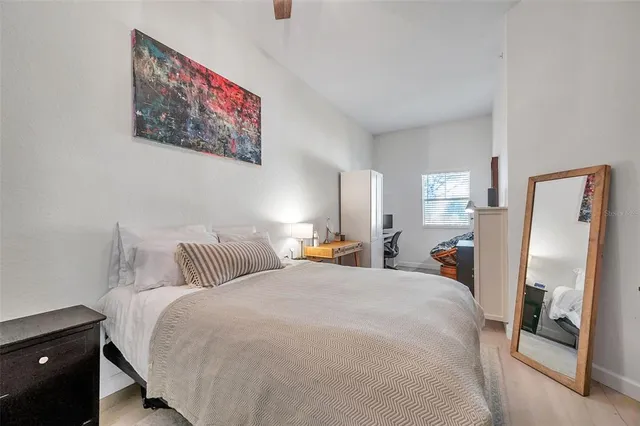 a bedroom with bed and a painting on the wall