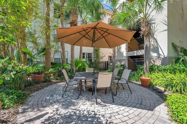 a view of patio with chairs and table under an umbrella