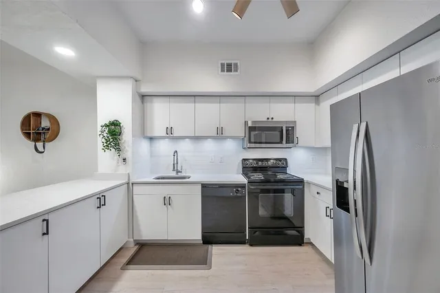 a kitchen with stainless steel appliances granite countertop a refrigerator sink and stove