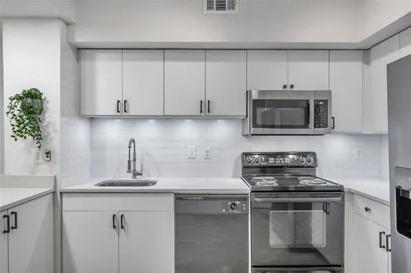 a kitchen with appliances a sink and cabinets