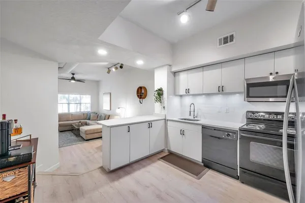 a kitchen with stainless steel appliances a stove sink and microwave