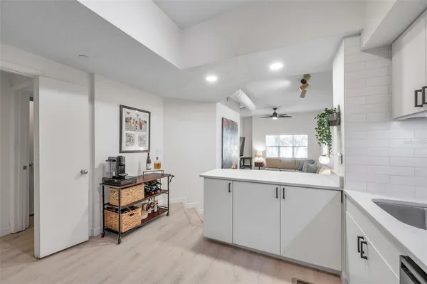 a kitchen with white cabinets and sink