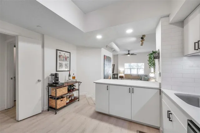a kitchen with white cabinets and sink