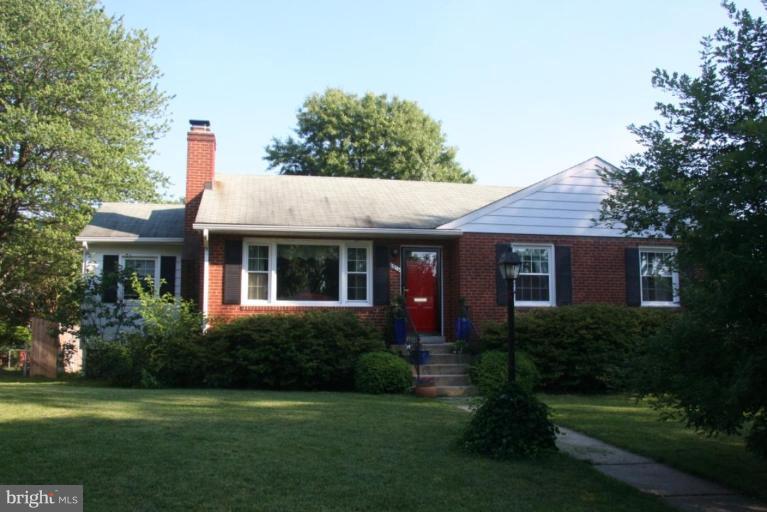 a front view of a house with a yard and trees