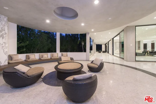 a living room with patio furniture and a potted plant