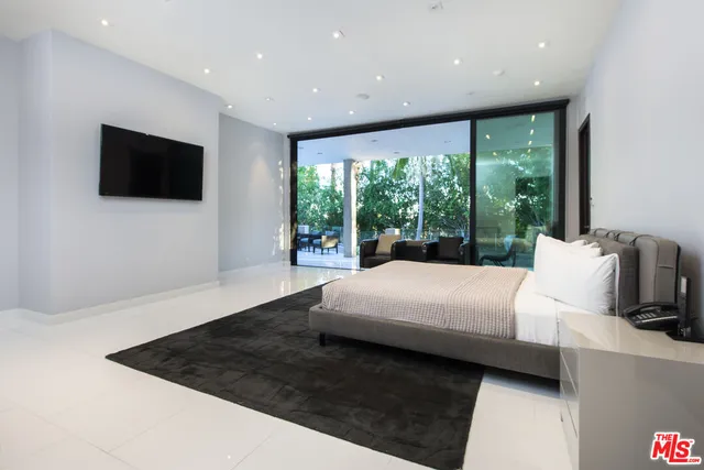 a large white bed sitting in a room next to a window