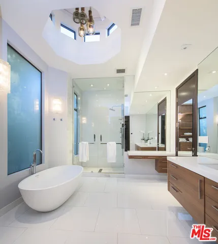 a spacious bathroom with a large tub shower and fireplace