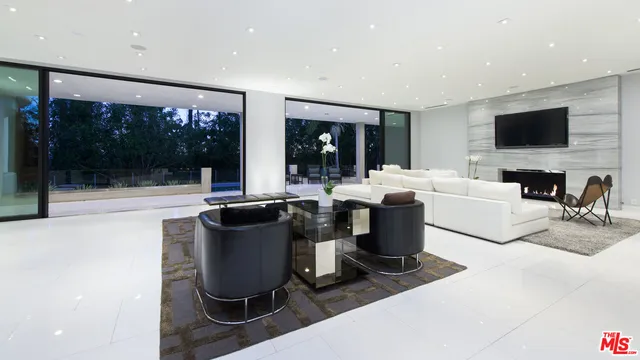 a living room with furniture a flat screen tv and a floor to ceiling window