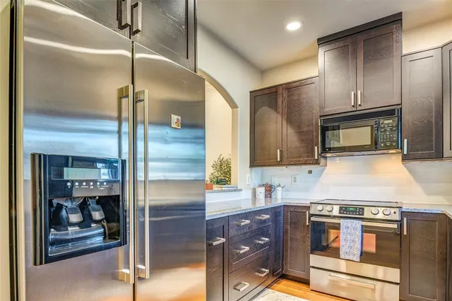 a kitchen with stainless steel appliances granite countertop a refrigerator and a stove
